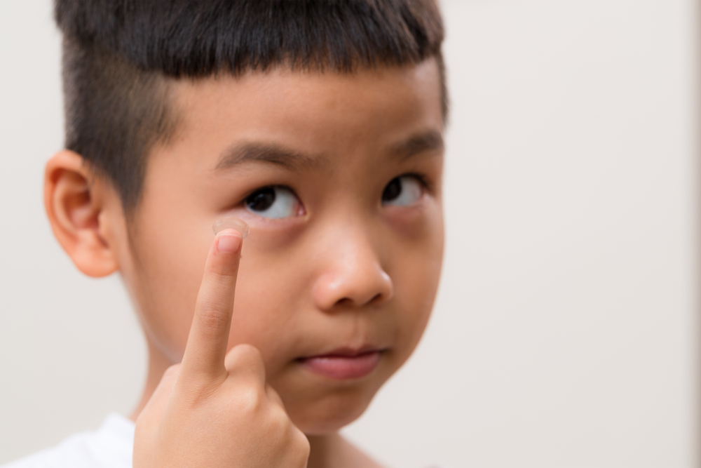 Asian,Little,Boy,Put,A,Contact,Lens,On,A,Finger