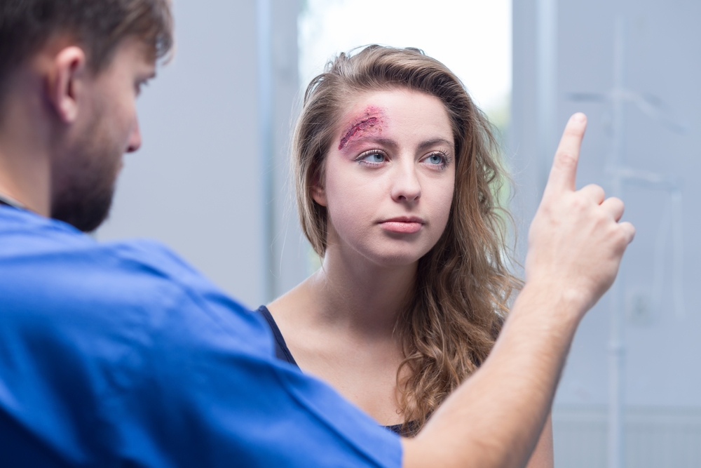 Picture,Of,Male,Doctor,Diagnosing,Injured,Woman