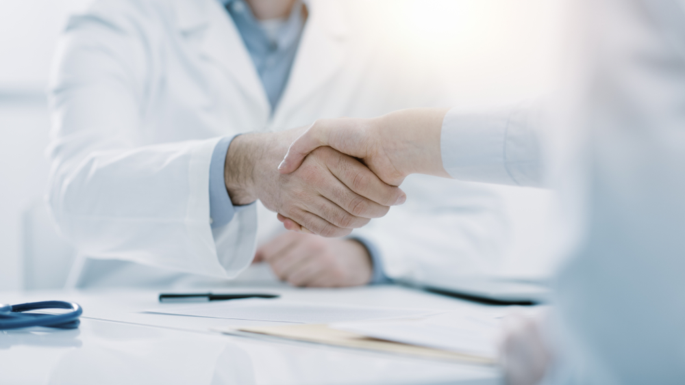 Doctor,And,Patient,Shaking,Hands,In,The,Office,,They,Are