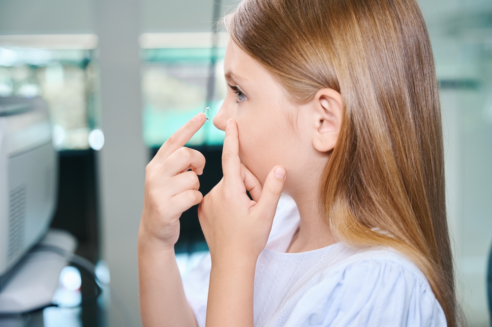Little,Girl,Practicing,To,Insert,Ophthalmic,Lenses,In,Optometry,Office